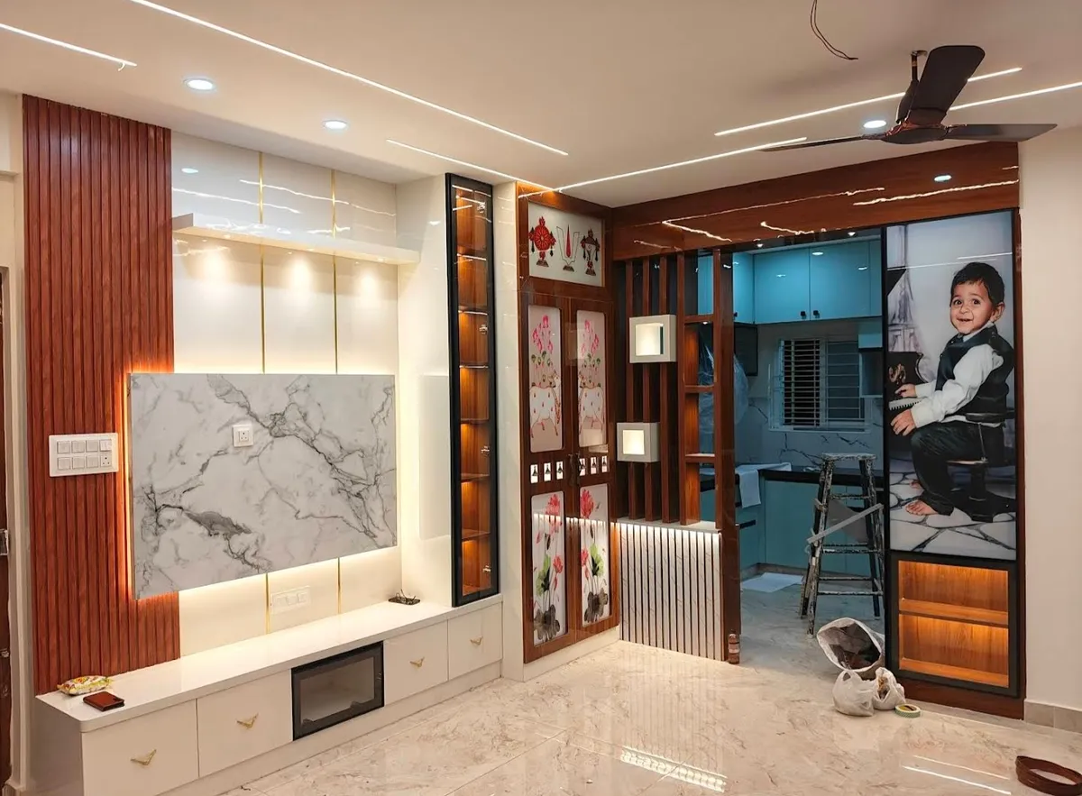 Near-complete living wall with a book-matched marble TV panel between rosewood flutes and a lit glass curio column