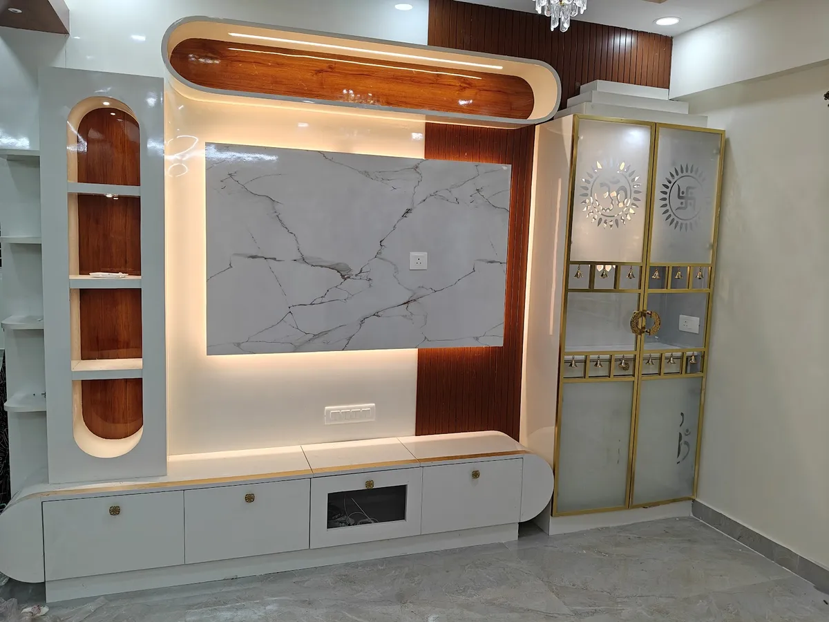 Living-room TV wall at handover: a backlit white marble slab framed by rust-toned grooved wood panelling under a curved capsule soffit