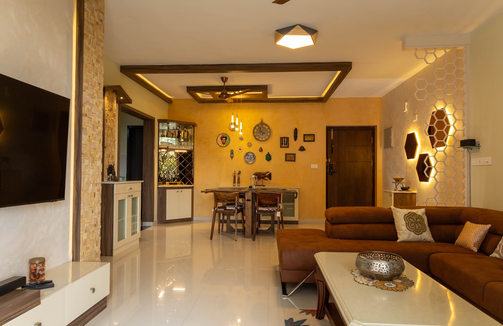 Open-plan living-dining space with a mustard textured accent wall styled with a curated wall-art and clock arrangement