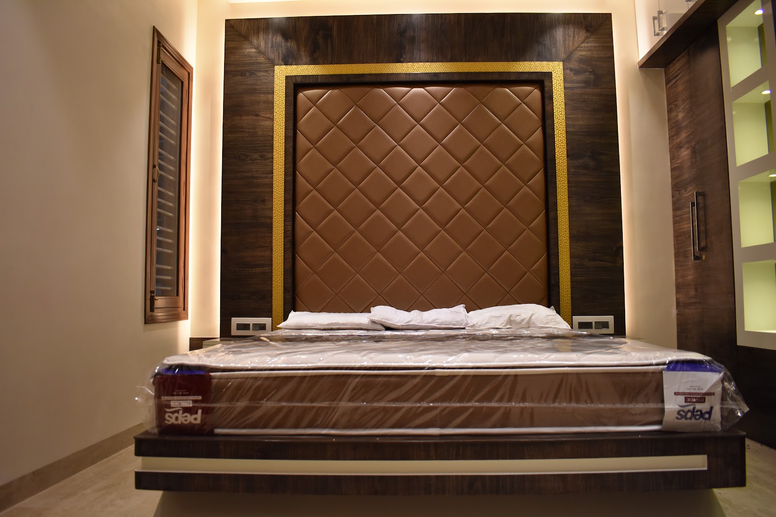 Master bedroom with a diamond-quilted tan leather headboard framed in gold trim against a dark wood panelled wall, and a floating wood bed base