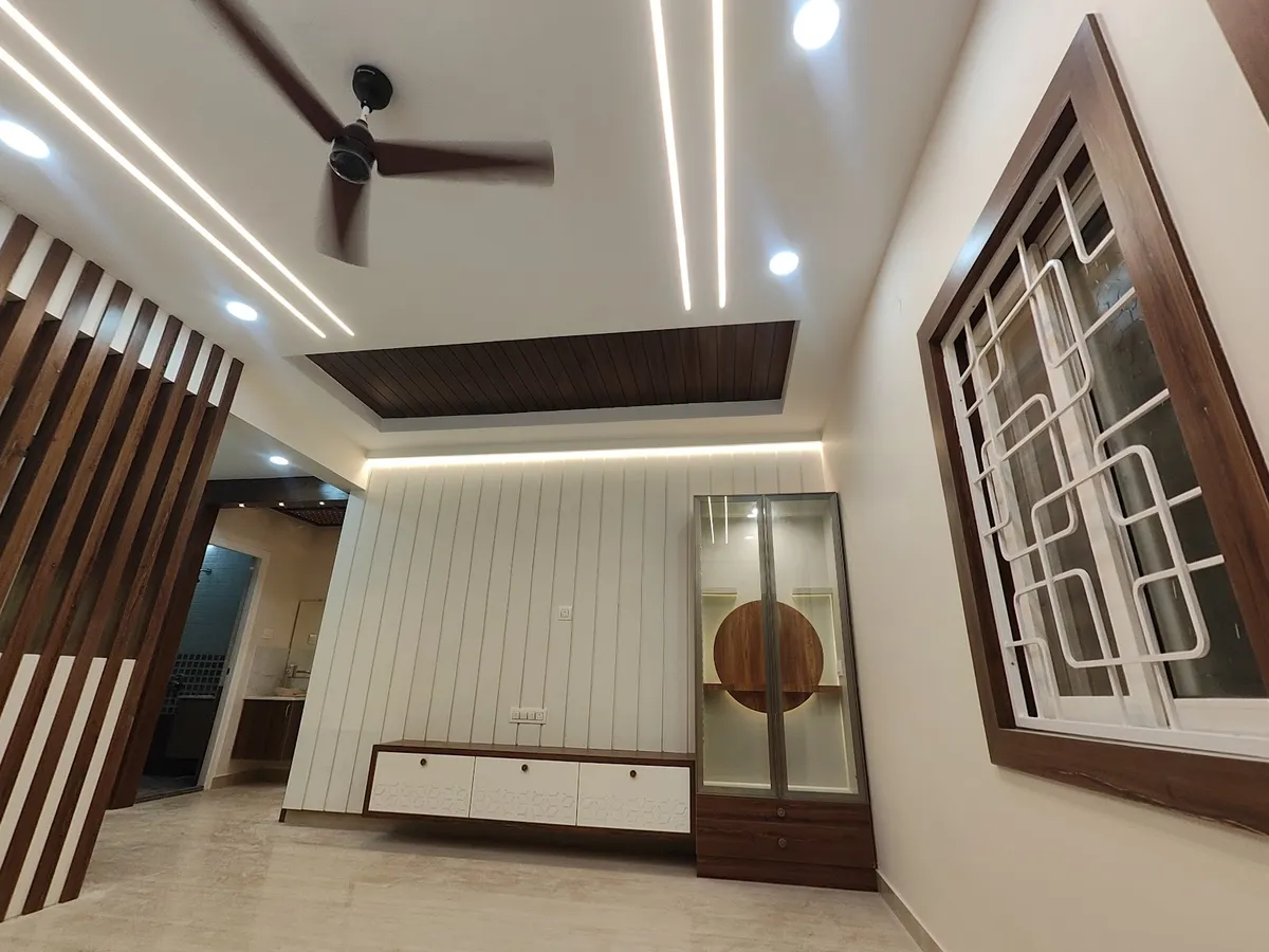 Freshly finished and still unfurnished hall with a white fluted TV wall, a floating white-and-walnut console