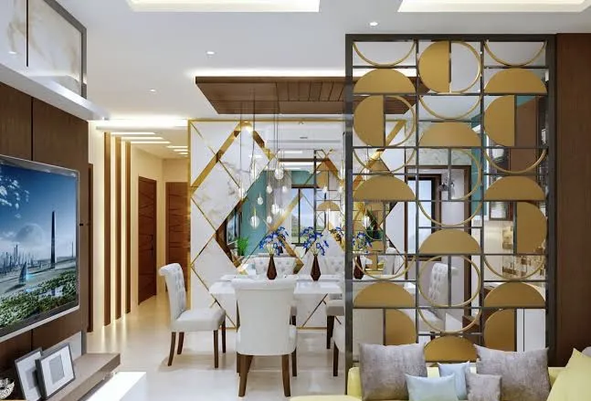Render of an open living-dining split by a floor-to-ceiling brass screen of overlapping gold discs and mirror