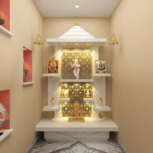 Render of a wall-niche pooja unit with a white stepped canopy, gold jaali backdrop panels and hanging bells flanking a marble platform