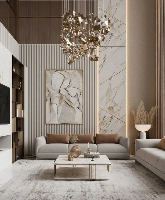 Render of a double-height living room with a cascading gold-leaf chandelier over a low cream sofa, a pale fluted panel wall carrying one large abstract canvas