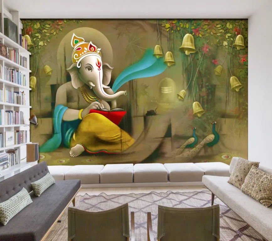 Living room shown with a full-wall Ganesha mural wallpaper — the deity reading beneath hanging brass bells with peacocks below — behind a long white banquette