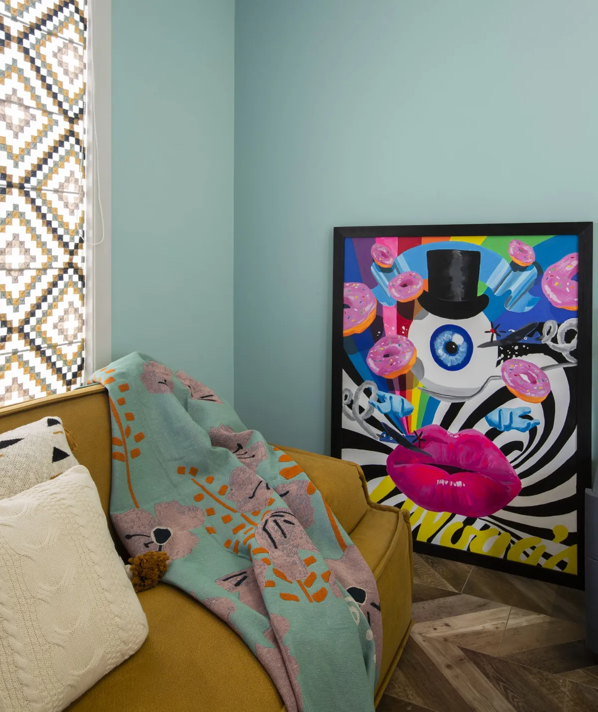 Mustard velvet settee with a folk-print throw and cream tasselled cushions in a mint-green corner