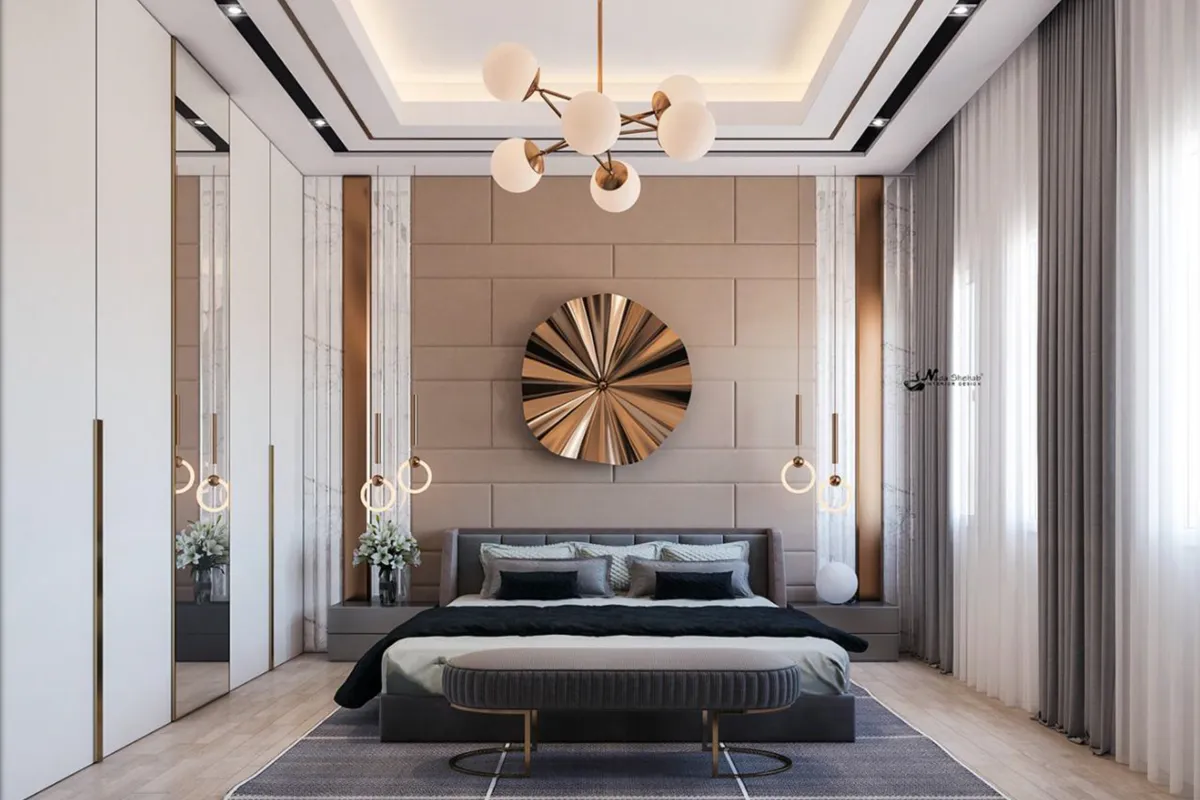 Render of a master bedroom where a grey channel-tufted bed stands against a taupe block-panelled wall under a brass sunburst disc