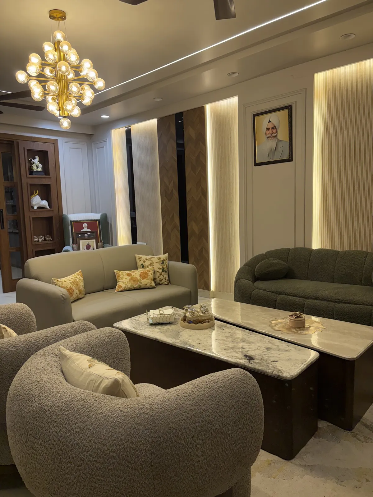 Formal drawing room with an olive boucle sofa facing a beige leatherette one, two curved boucle tub chairs, twin marble-top tables