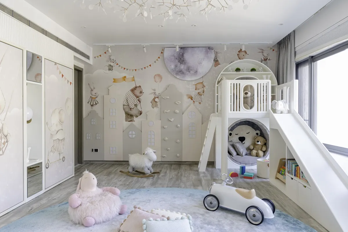 Pastel kids' room where a storybook animal mural meets a row of padded house-shaped panels studded with climbing holds