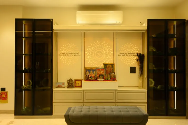Cream pooja unit with a backlit Om-and-mandala panel and etched Sanskrit shlokas on the side shutters