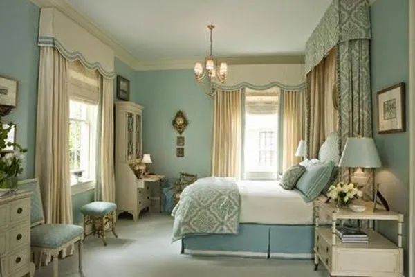 A pastel seafoam-and-cream traditional bedroom with an elaborate valance curtain treatment, a chandelier and a matching quilted bedspread.