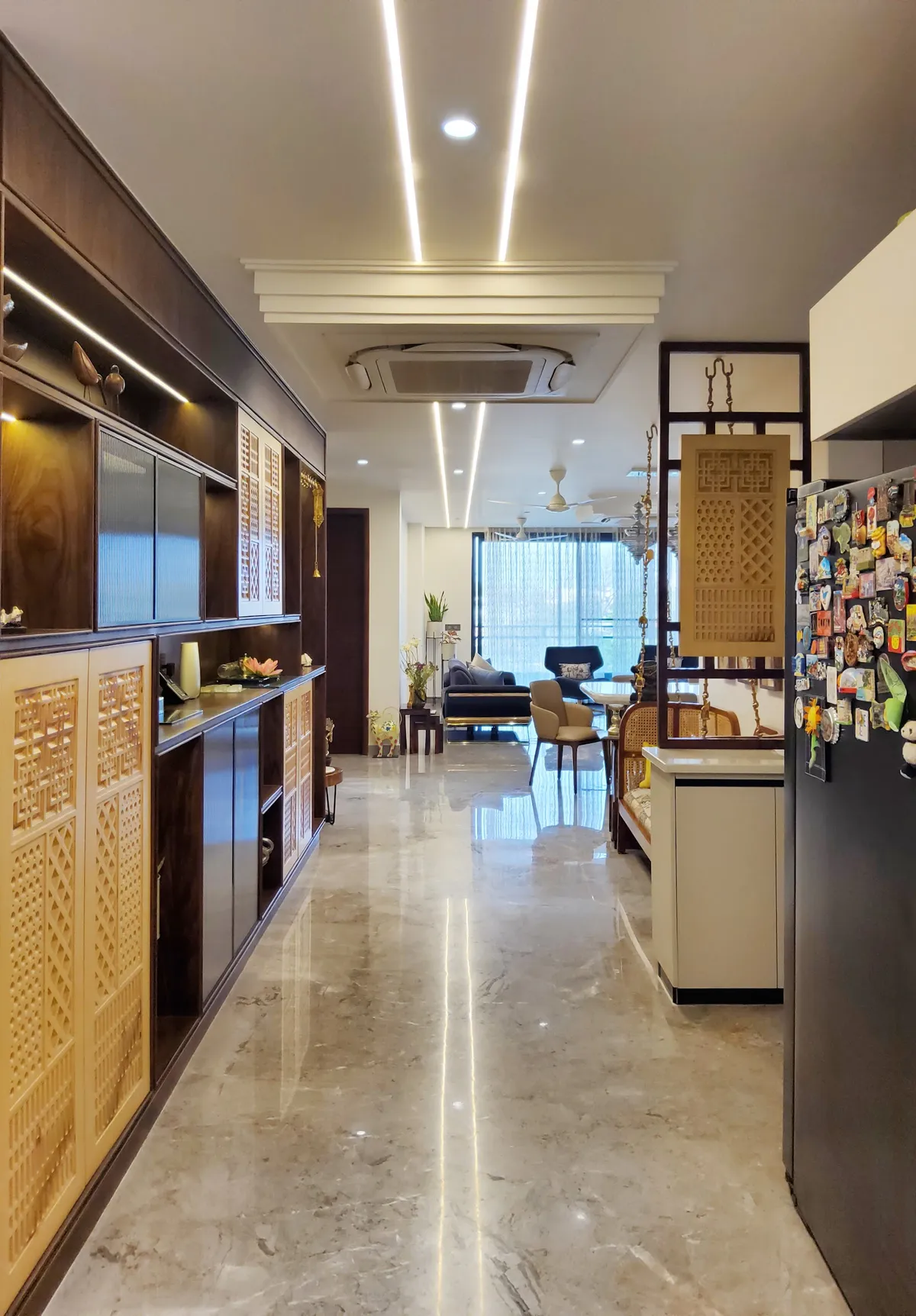 Marble-floored entrance passage lined with dark wood cabinetry featuring carved jaali panel doors