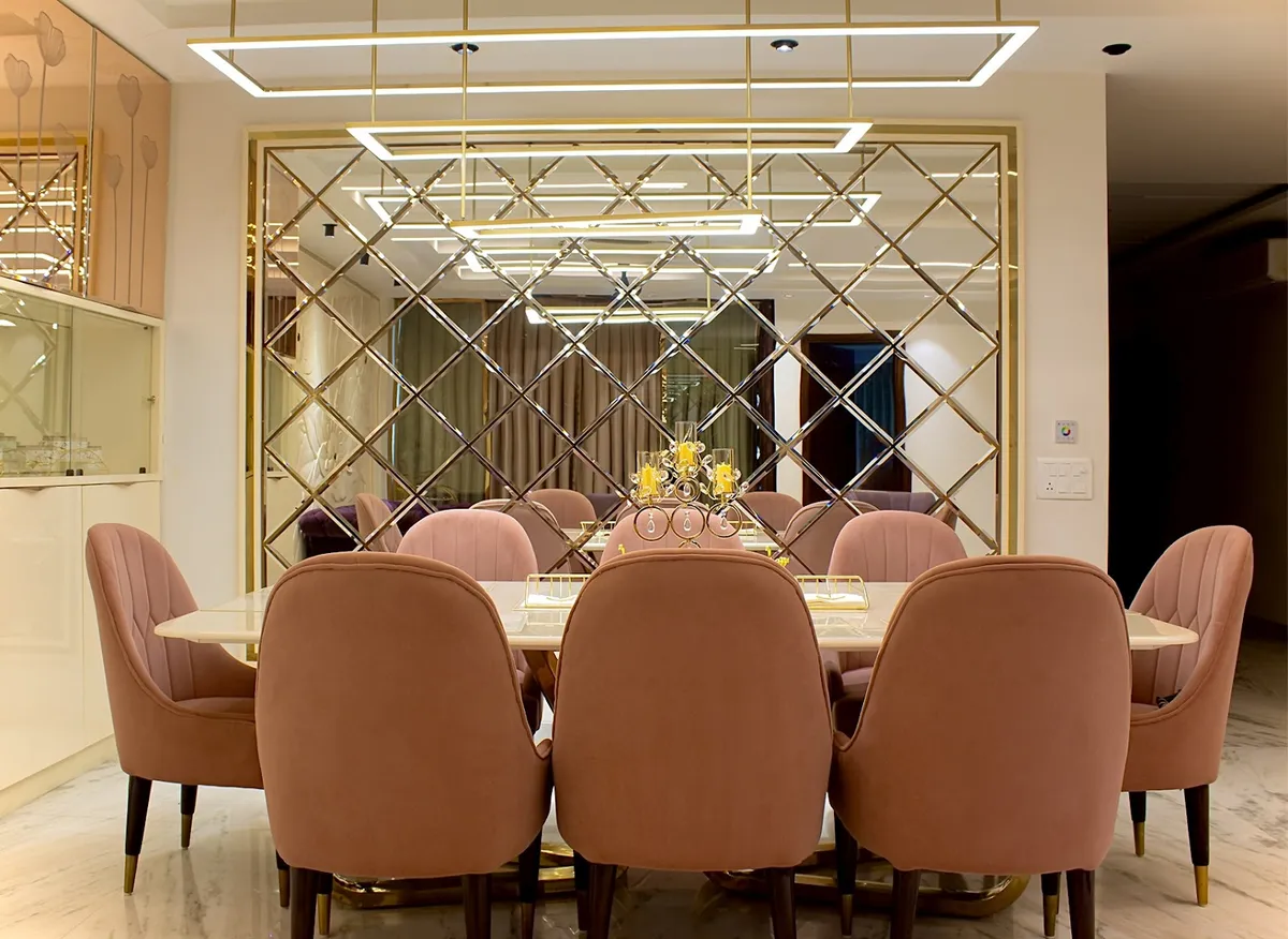 Real photo of a dining room with blush-pink velvet channel-tufted chairs around an oval marble table