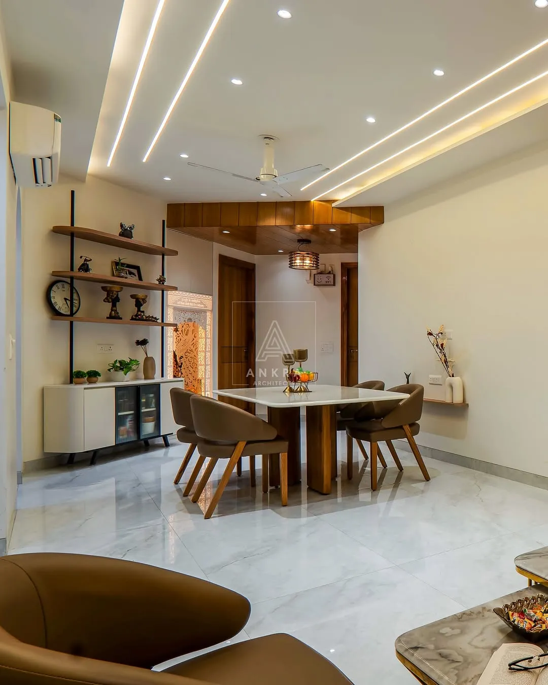 Dining area with a square marble-top table on a fluted wood pedestal and four tan leather tub chairs