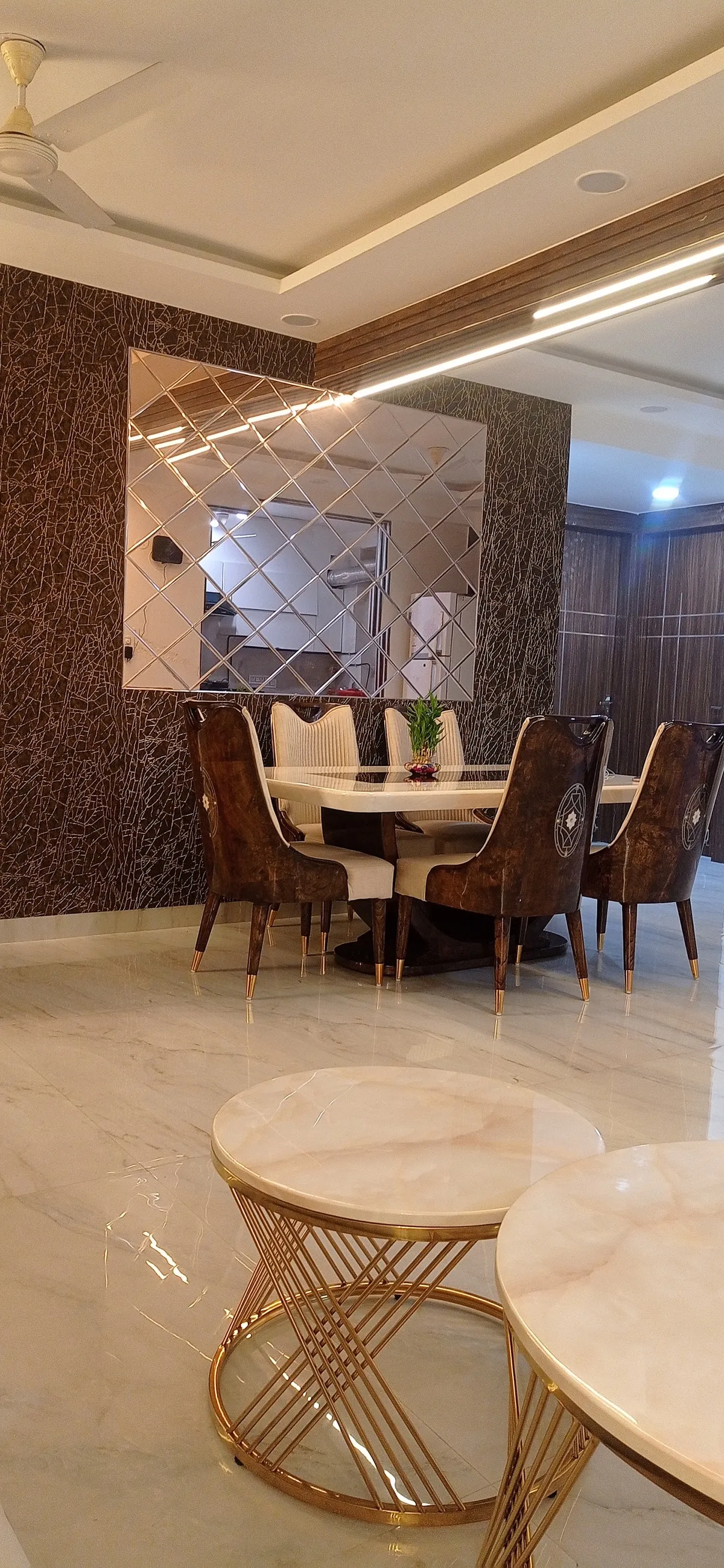 Six-seater dining set in burl-print leatherette chairs with brass-tipped legs around a cream marble table