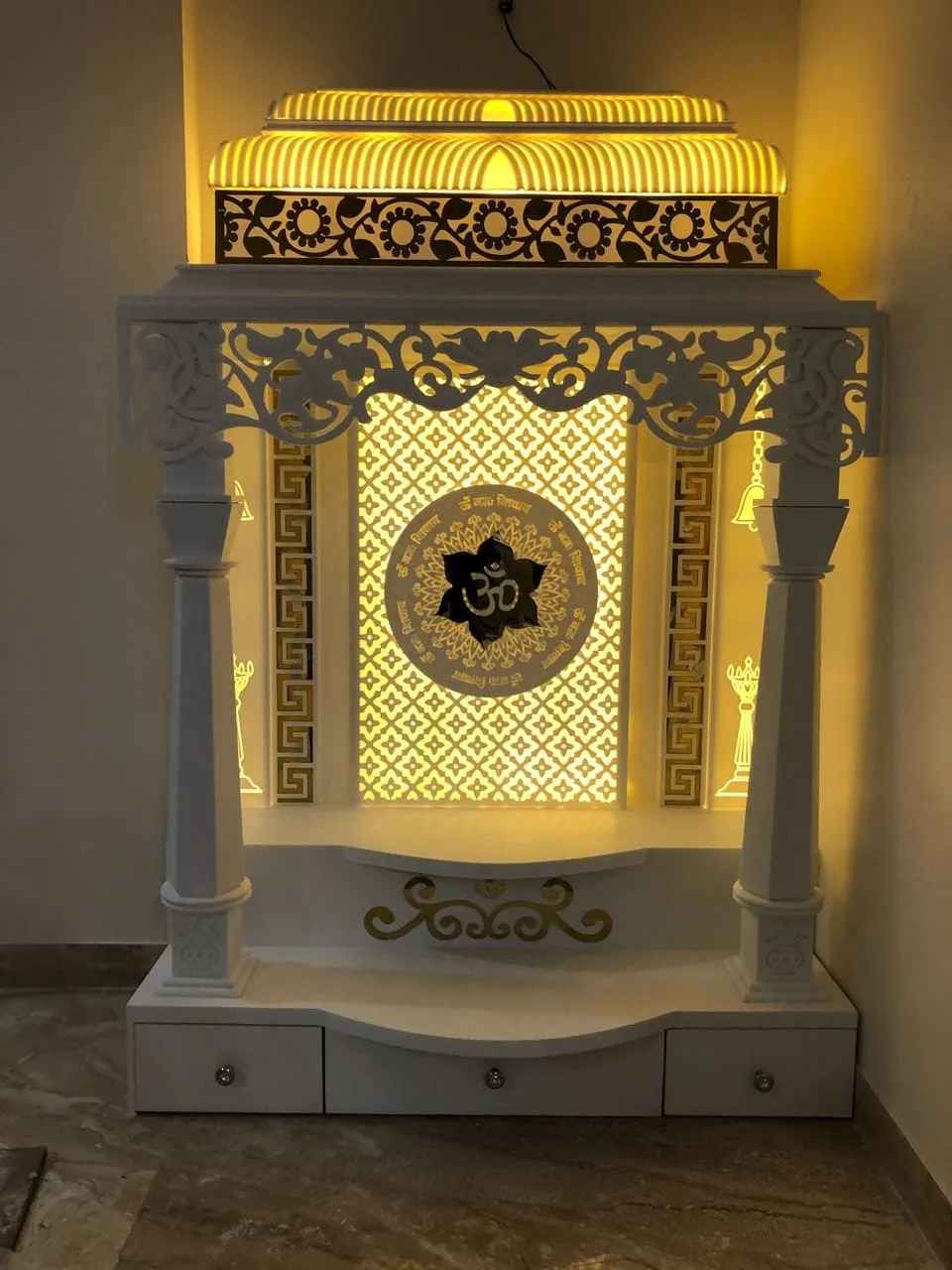 White temple unit built into a corner, with turned pillars, a carved lotus valance