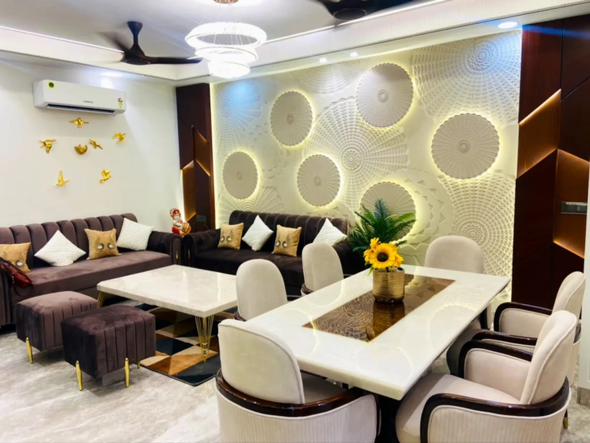 Living-dining hall with a marble-top six-seater against a backlit wall of white 3D carved discs
