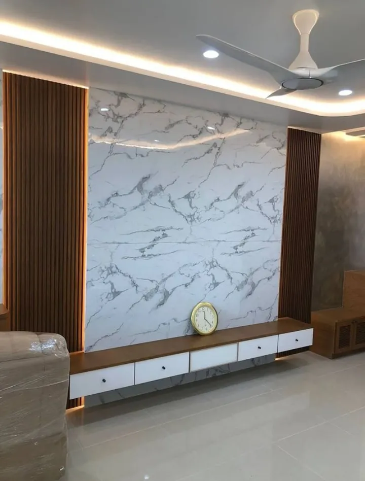TV feature wall in bookmatched white-and-grey marble flanked by vertical wood fluting