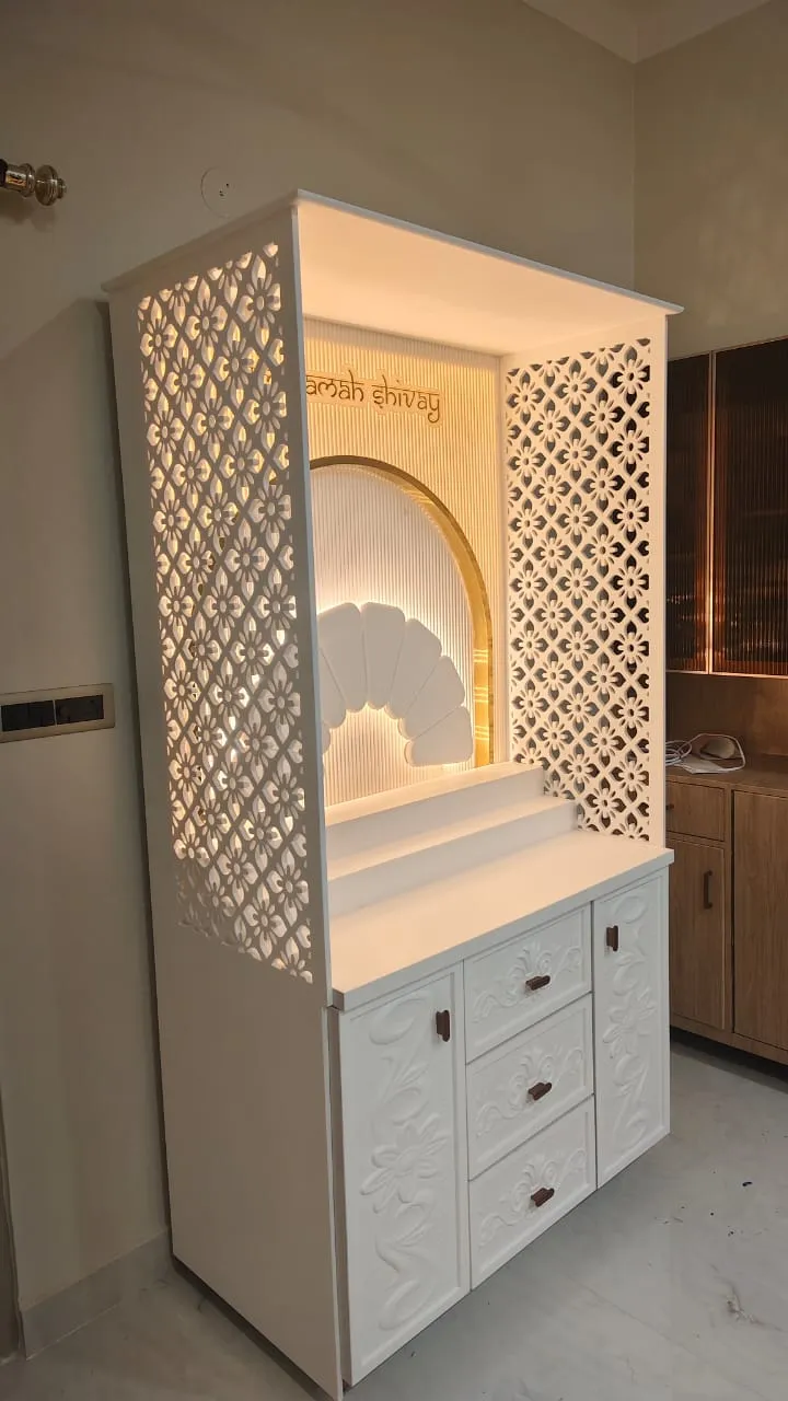 Freestanding white mandir with CNC floral-jaali side and back screens, a backlit fluted arch carrying 'namah shivay' lettering