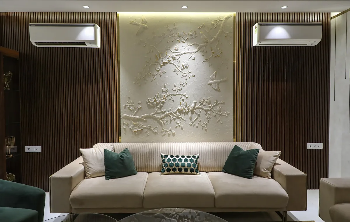 Living room where a hand-carved white plaster relief of blossom branches and two birds fills a backlit