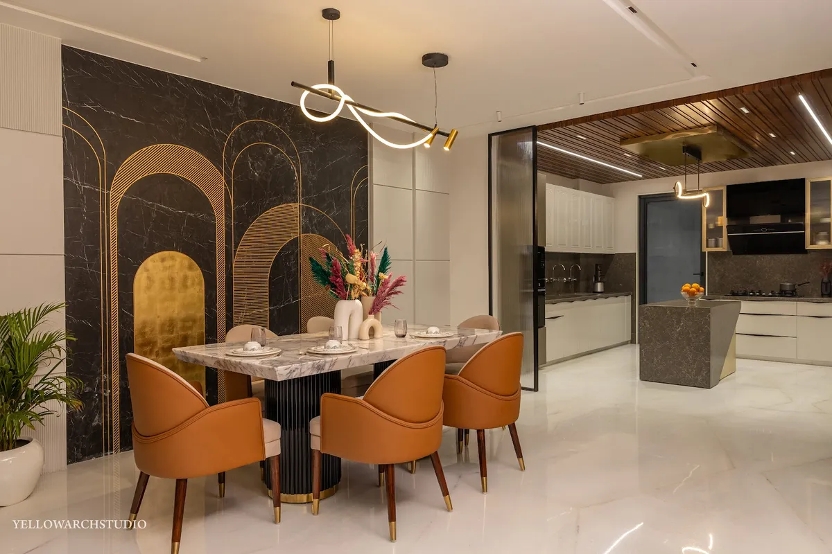 Dining area with a black marble and brass arch-pattern feature wall, a marble-top dining table and tan leather bucket chairs