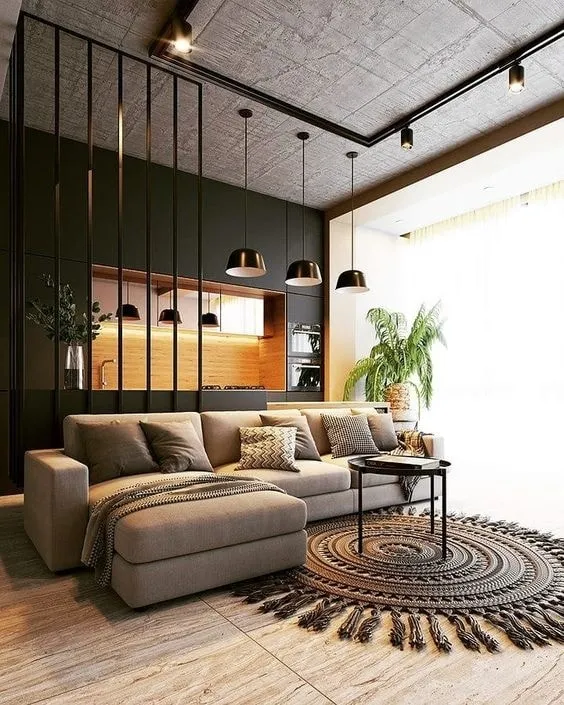 Render of a living room with a bare board-marked concrete soffit and black surface track, a beige L-sectional with a chaise facing a round fringed jute rug