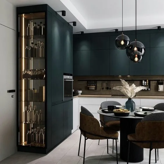Render of a handleless forest-green kitchen with a walnut backsplash rail, a floor-to-ceiling backlit bottle-and-glassware column at the entry