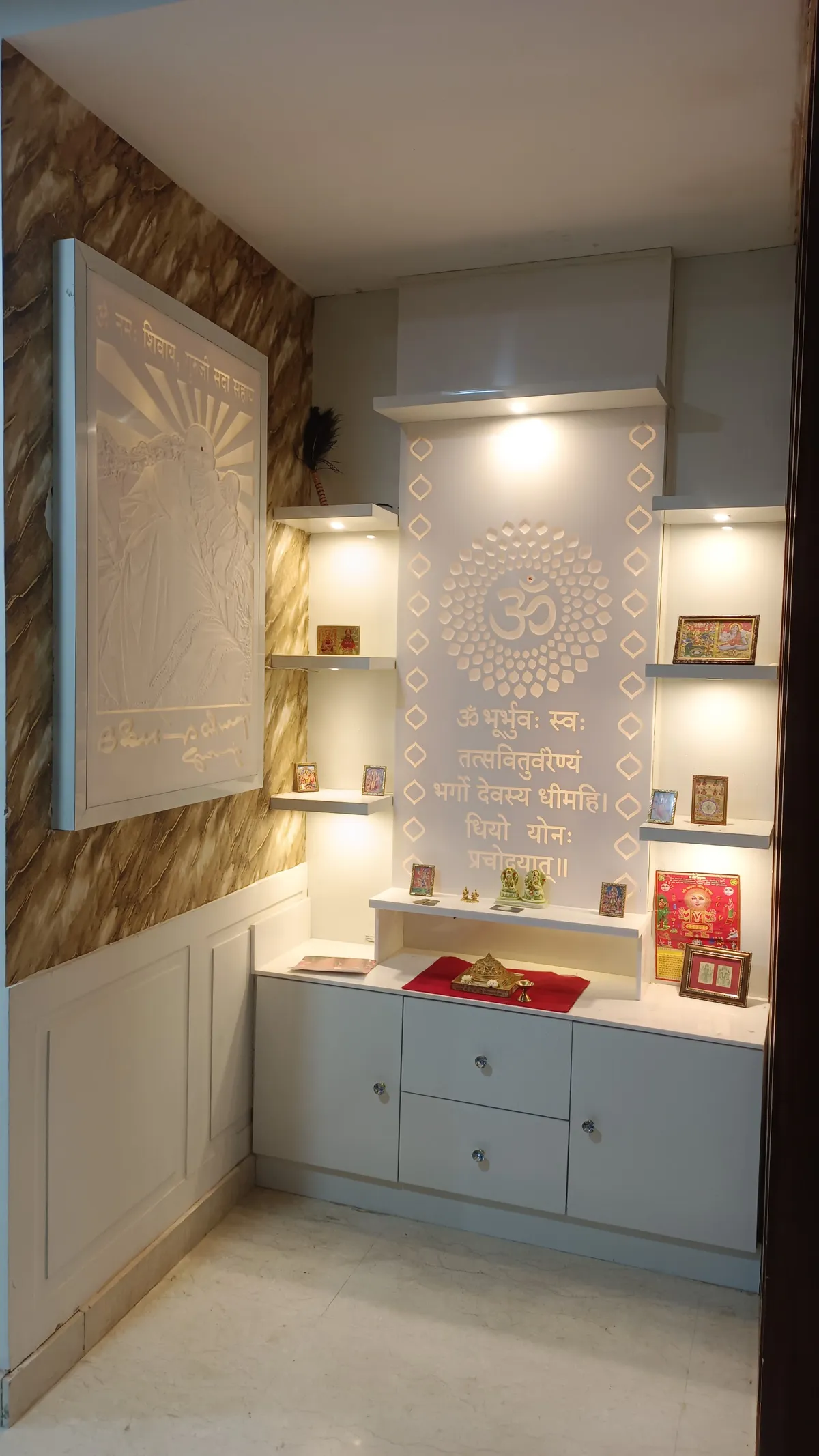 Built-in pooja unit with a backlit CNC-cut om medallion and Gayatri mantra inscribed above the deity shelf, flanked by lit display niches
