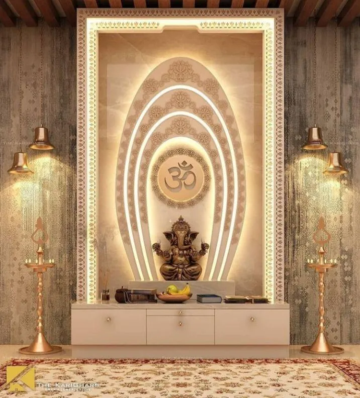 Render of a pooja unit with a backlit arched marble-effect niche framing a Ganesh idol, flanked by brass diya lamps on a textured accent wall.