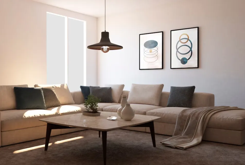 Render of a beige L-shaped sectional under a black dome pendant, with two abstract circle-motif prints and a bonsai on a marble-topped coffee table
