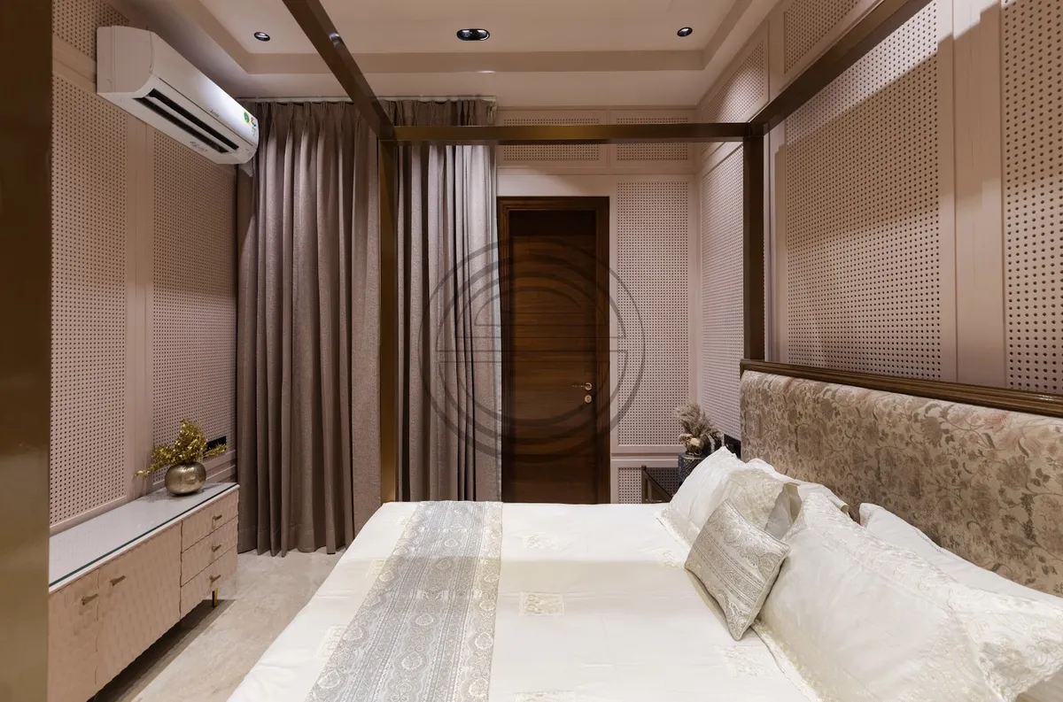 Master bedroom lined floor to ceiling in beige CNC-perforated panelling divided by brass inlay strips