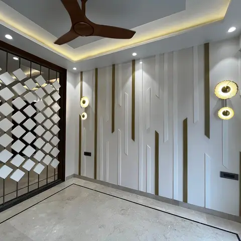 Entrance foyer with a diamond-tessellated metal-and-tile jaali screen beside a fluted brass-inlaid feature wall.