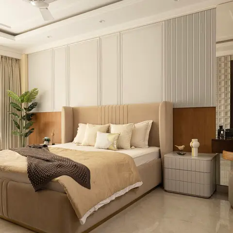 Beige wingback upholstered bed against a white-panelled and wood-clad wall, with an adjoining dressing table and round