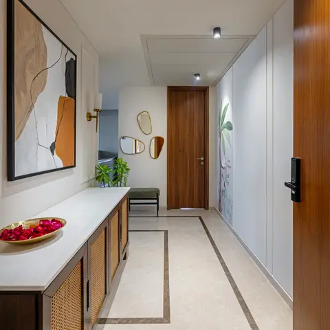 Marble-floored entrance foyer with a walnut main door, digital smart lock, a rattan-front console beneath abstract art, and