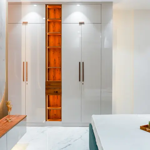 Bedroom with a floor-to-ceiling glossy white wardrobe featuring a backlit wood display niche, wall-mounted TV on
