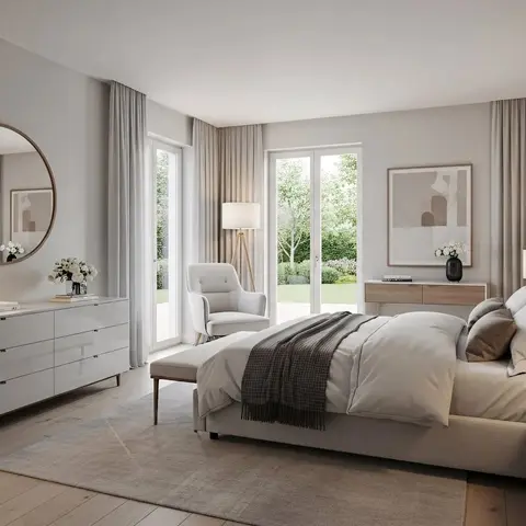 airy master bedroom with an upholstered bed against a wood-panelled wall, a round mirror over a long six-drawer dresser, and