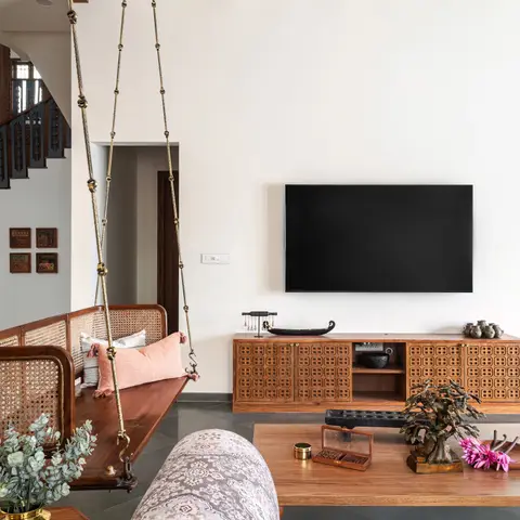 living room with a traditional wooden hanging swing with cane backrest, a fretwork-front wood TV console, and a coffered