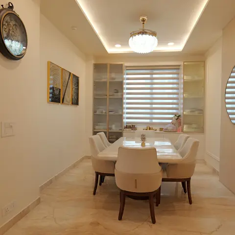 formal dining room with a marble-top table and cream upholstered chairs, fluted-glass crockery cabinets flanking a