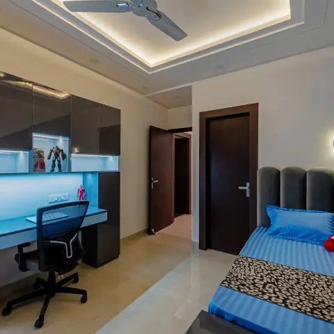 a boy's bedroom with a backlit blue-glow study unit displaying superhero action figures and a globe, a scalloped