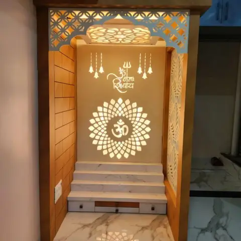 Backlit pooja unit niche with a carved Om jaali panel, arched wooden frame, marble steps and a drawer base