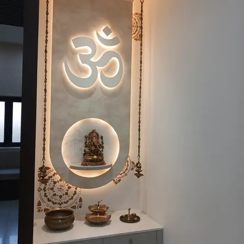 Modern pooja niche with a backlit Om symbol above a circular backlit shelf for a Ganesha idol, and a floating drawer console