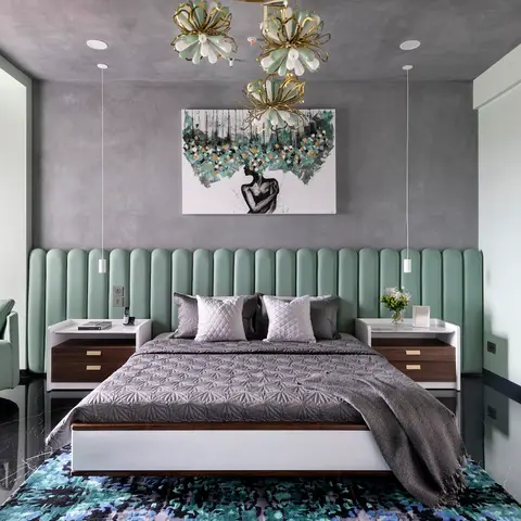Master bedroom with a sage-green channel-tufted headboard wall and a gold floral chandelier cluster over the bed, on glossy