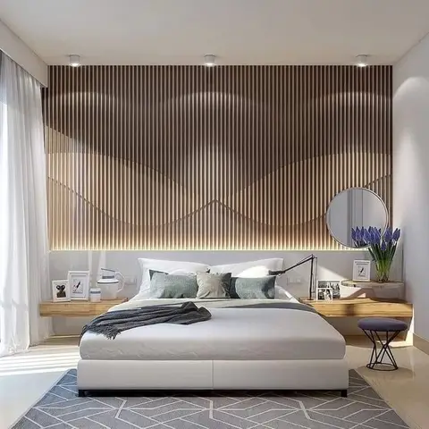 Bedroom with a floor-to-ceiling wavy wood-slat feature wall lit from behind, floating wood nightstand shelves, a round