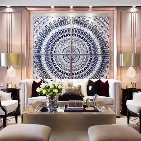 Formal living room with a large circular mandala wall-art panel flanked by pendant lamps, wingback chairs and a mirrored