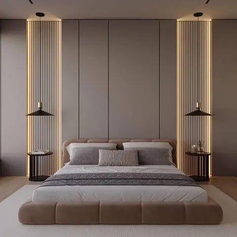 Low platform bed with a tufted upholstered base centered between two backlit fluted-wood panel columns and matching pendant