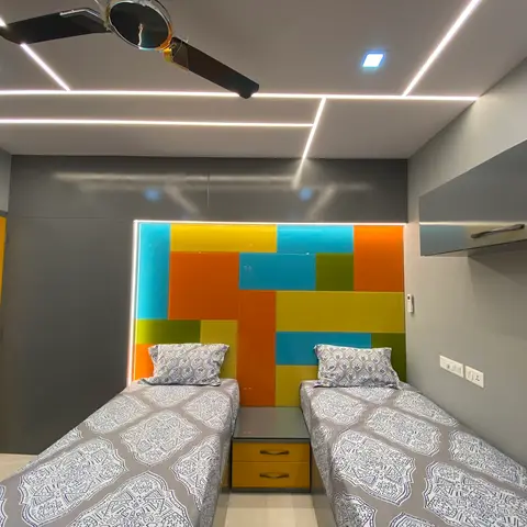 Kids bedroom with twin beds flanking a colour-blocked orange, teal, yellow and green headboard wall panel, and a yellow