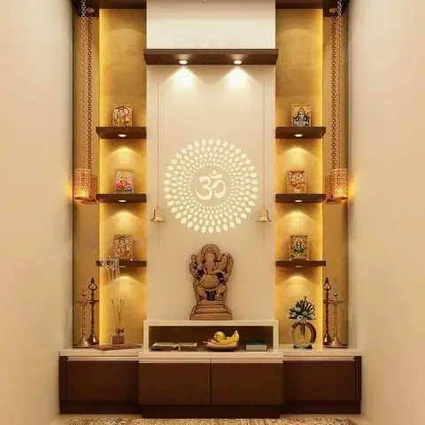 Backlit pooja unit with a carved Ganesha idol, an Om jaali cutout panel and symmetrical deity shelving flanked by hanging