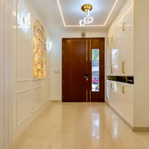 Grand entrance foyer with a wooden double main door, backlit onyx wall panel, fluted wall cladding, and full-height