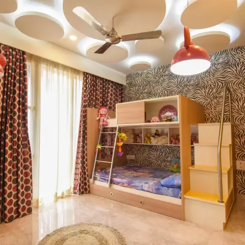 Kids bedroom with a built-in wood bunk bed with storage stairs, zebra-print wallpaper, playful Mickey Mouse-shaped pendant