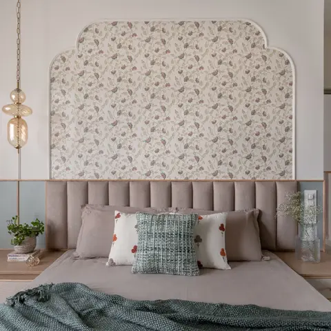 Bedroom with a channel-tufted headboard set against an arched floral-wallpaper wall, flanked by built-in wood nightstands